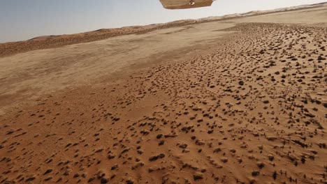 Blick-Aus-Der-Seite-Eines-Kleinen-Flugzeugs-Während-Eines-Tiefflugs-über-Namibias-Weite-Wüstenvegetation-Fliegt-Vorbei,-Während-Das-Flugzeug-Von-Turbulenzen-Durchgeschüttelt-Wird