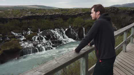 Handsome-young-male-looking-at-a-beautiful-view-at-Barnafoss-waterfall-in-Iceland-is-portrait