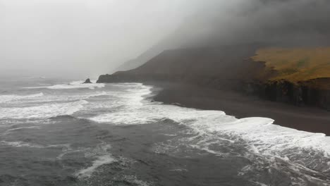 Aerial-footage-over-a-black-beach-in-Djupavogshreppur,-Iceland