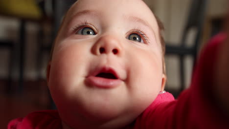 Kleines-Süßes-Baby-Lächelt-Und-Schnappt-Sich-Ein-Spielzeug-Vor-Der-Kamera,-Aufgenommen-In-Zeitlupe