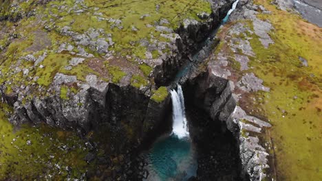 Luftaufnahmen-Von-Oben-In-Den-Isländischen-Bergen,-Die-Einen-Wasserfall-Zeigen,-Der-Von-Oben-Aufgenommen-Wurde-Und-Absteigt