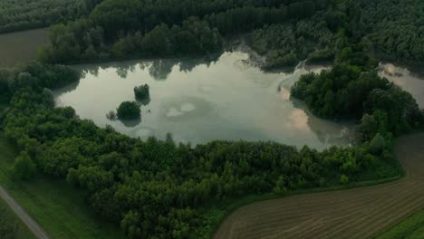 4k-Luftbild:-Schnelle-Filmische,-Aufschlussreiche-Aufnahme-Einer-Ländlichen-Landschaft-Mit-Einem-Reflektierenden-Natürlichen-See