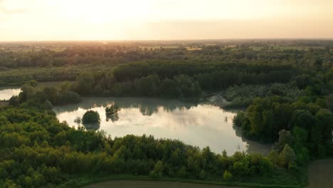 4K-Aerial-:-Cinematic-spotlight-shot-over-a-natural-lake-with-clouds-reflected-inside-in-a-rural-landscape