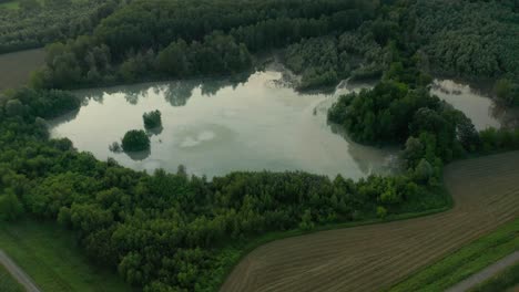 4K-Aerial-:-Cinematic-spotlight-shot-over-a-natural-lake-in-a-typical-italian-rural-lanscape