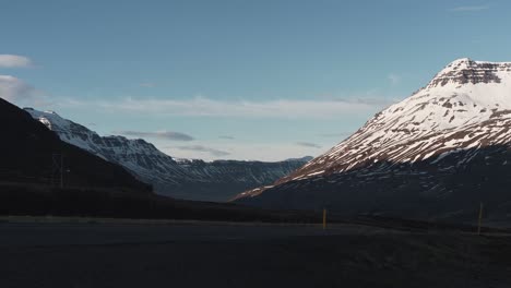 Panorámica-De-Izquierda-A-Derecha-Que-Muestra-Montañas-Cubiertas-De-Nieve-Y-Una-Carretera-En-Islandia-Cerca-De-Seydisfjordur-2