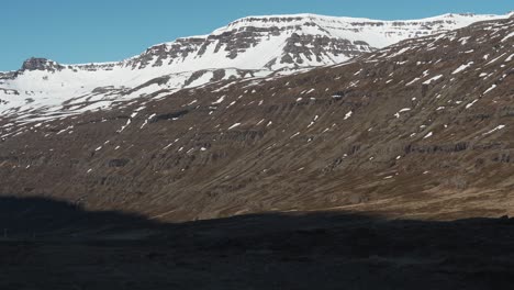 Panning-from-left-to-right-showing-some-snow-covered-mountains-located-close-to-Gufufoss-in-Iceland