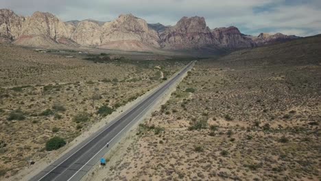 Fliegen-Entlang-Einer-Straße-In-Der-Wüste-Von-Nevada-Mit-Bergen-Im-Hintergrund