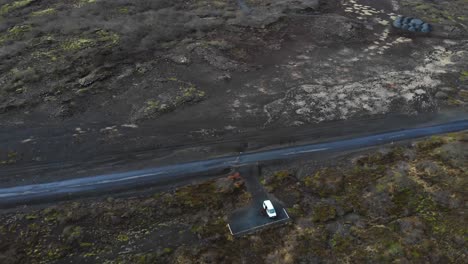 Luftaufnahme-über-Eine-Schotterstraße-Im-Isländischen-Hochland,-Die-Die-Epische-Landschaft-Und-Ein-Wohnmobil-Zeigt,-Das-Auf-Einem-Parkplatz-Am-Straßenrand-Lagert