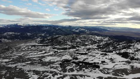 Drone-shot-of-the-mountains-and-the-valley-bellow,-dotted-with-snow
