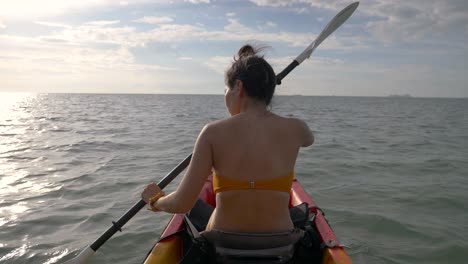 Mujer-Haciendo-Kayak-Y-Observando-El-Mar,-Contra-El-Sol