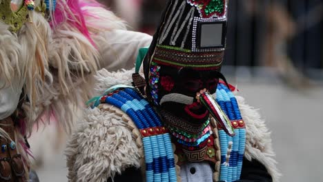 Slow-motion-shof-of-kid-kuker-towards-adult-bulgarian-kuker-wearing-costume-decorated-with-wool-and-beads