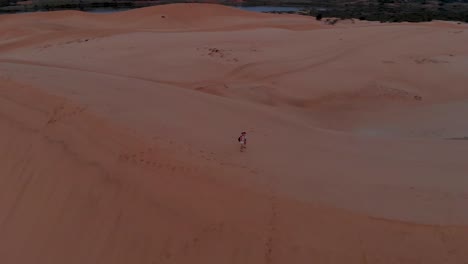 Cinematic-aerial-drone-shot-of-golden-sunrise-over-the-remote-sand-dunes-of-vietnam-with-untouched-sand-and-cloudy-sky-3