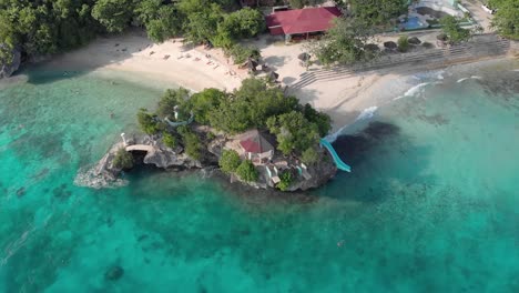 Cinematic-aerial-drone-shot-of-iconic-resort-in-philippines-island,-with-crystal-clear-blue-water,-white-sand-and-cliff-jumping-on-hot-sunny-summer-day-1