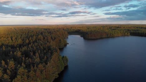 Aerial-footage-of-a-lake-in-a-Swedish-forest-during-sunset