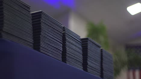 Slow-pan-left-of-Navy-Blue-Leather-Cased-Diplomas-stacked-with-American-flag-in-background