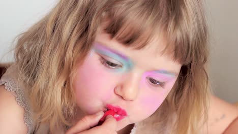 Close-up-of-a-Little-girl-applying-lipstick-while-watching-herself-in-the-mirror