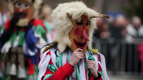 Bulgarisches-Kuker-Kostüm-Mit-Holzmaske-Und-Gebogener-Roter-Nase-Und-Bulgarischen-Flaggenelementen-Auf-Der-Brust