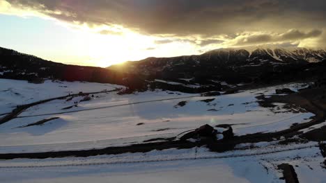 Drone-shot-of-an-amazing-sunset-behind-the-mountains-during-winter