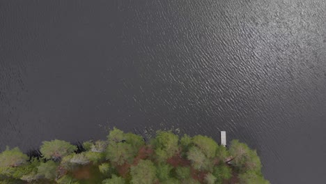 Aerial-footage-of-a-bridge-in-the-forest-at-the-edge-of-the-lake-at-skoludden-looking-straight-down-at-the-viewpoint-from-where-you-see-the-island-that-floats-up-every-summer