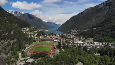 Drone-capturing-a-football-field-in-the-town-of-Odda,-Norway-during-summer