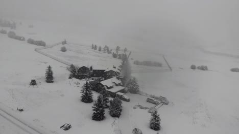 Drone-shot-of-a-log-home-in-the-country-during-an-intense-blizzard