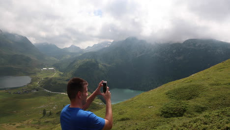 Traveler-records-landscape-of-Lake-Ritom-in-the-middle-of-the-Swiss-Alps-for-his-social-media-accounts