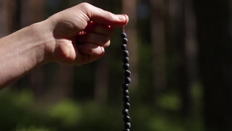 Hand-holding-blueberries-picked-in-a-Swedish-forest-stacked-on-a-straw-hanging-down