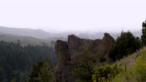 Light-rain-on-a-sunny-day-over-the-valley-and-a-boulder