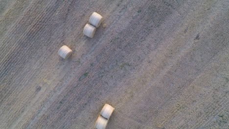 Slowly-flying-away-in-a-spiral-from-farmland-to-reveal-more-rolling-fields-and-hay-bales