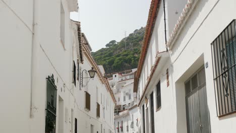 Dolly-of-a-narrow-all-white-Mediterranean-village-street-during-a-sunny-day