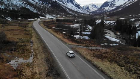 Drone-following-a-riding-car-in-a-mountainous-landscape