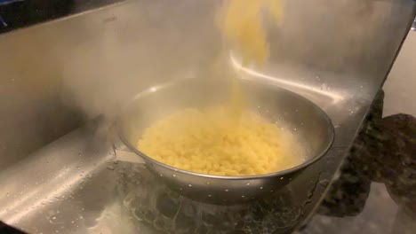 Pouring-Boiled-Pasta-Water-Over-Sink