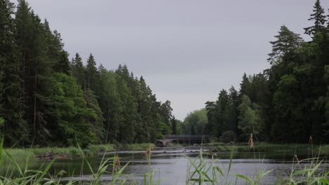 View-of-river-"dalälven"-in-Sweden-passing-through-the-national-park-in-Gysinge,-Gästrikland-and-below-a-bridge