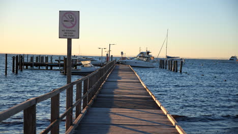 Pan-across-sunny-wharf-pier-with-boats