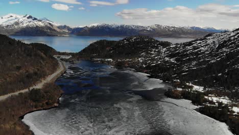 Rising-drone-capturing-melting-lake-in-a-valley-during-spring