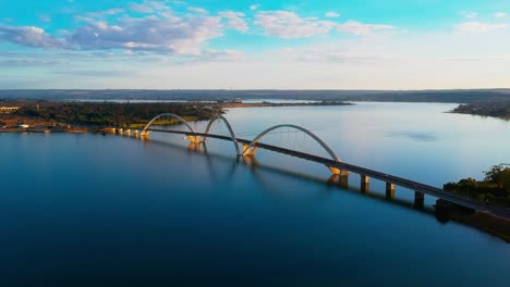 Static-aerial-HD-drone-footage-of-the-Paranoa-Lake-and-JK-Bridge-in-Brasilia,-Brazil-with-cars-moving-across-the-bridge-in-the-distance