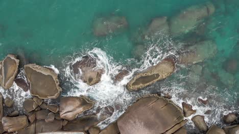 Aerial-view-of-ocean-waves-crashing-on-rocks