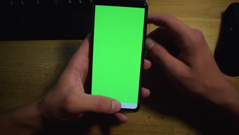 Young-adult-boy-hold-smartphone-with-a-greenscreen-in-his-hands-18