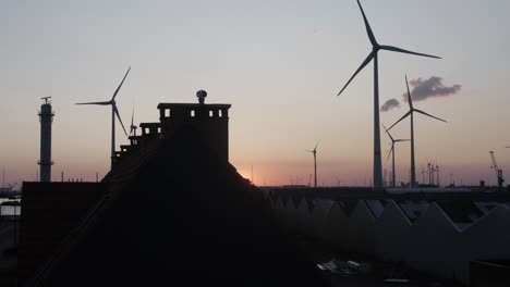 Filmische-Zeitlupenaufnahme-Von-Windturbinen-Im-Hintergrund-Während-Des-Sonnenuntergangs
