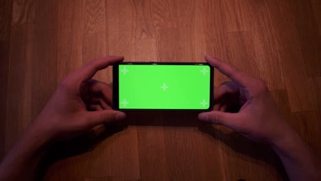 Young-adult-boy-hold-smartphone-with-a-greenscreen-in-his-hands-12