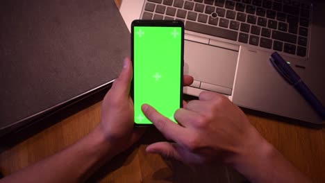 Young-adult-boy-hold-smartphone-with-a-greenscreen-in-his-hands-3