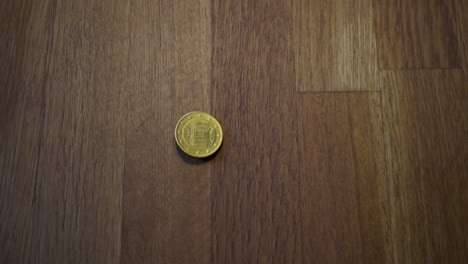 Rotierende-Münze-Auf-Einem-Holztisch-11
