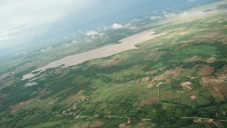 Aerial-view-of-green-field-and-lake,-Cambodia
