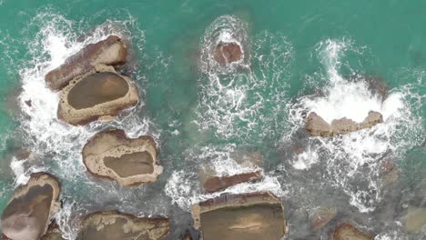 Aerial-view-of-ocean-waves-crashing-on-the-rocks,-Drone-shots
