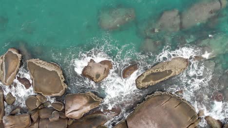 Aerial-view-of-ocean-waves-crashing-on-the-rocks