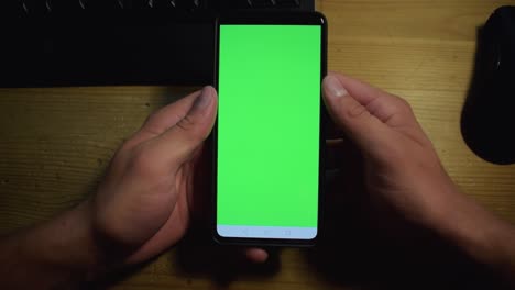 Young-adult-boy-hold-smartphone-with-a-greenscreen-in-his-hands-19