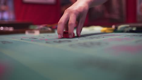 A-Croupier-is-handling-the-chips-on-a-roulette-table-with-his-rake-while-the-wheel-is-spinning