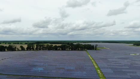 Solar-Farm-Reveal-and-Flyover-Through-Trees-in-Rural-Farm-Land