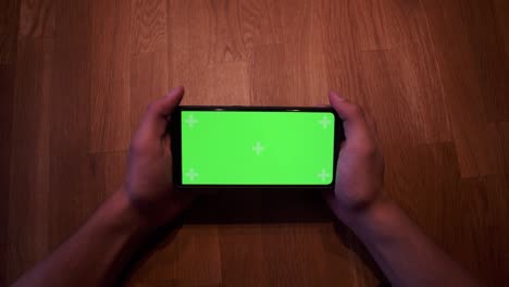 Young-adult-boy-hold-smartphone-with-a-greenscreen-in-his-hands-10
