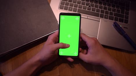 Young-adult-boy-hold-smartphone-with-a-greenscreen-in-his-hands-6